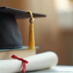 Graduation cap on books with diploma on laptop. Online education concept, university study. Student degree certification. E-learning, distance learning, education achievement, high school, master